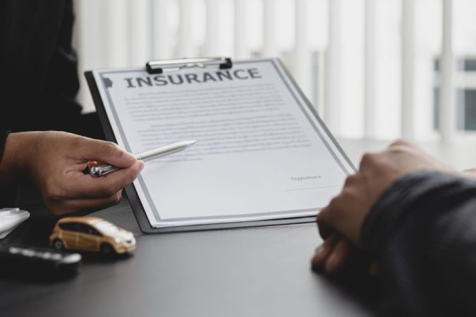 Une main d'assureur présente un contrat d'assurance habitation pour une signature, tandis que la garantie vol après effraction de serrure est mise en avant pour un remboursement.